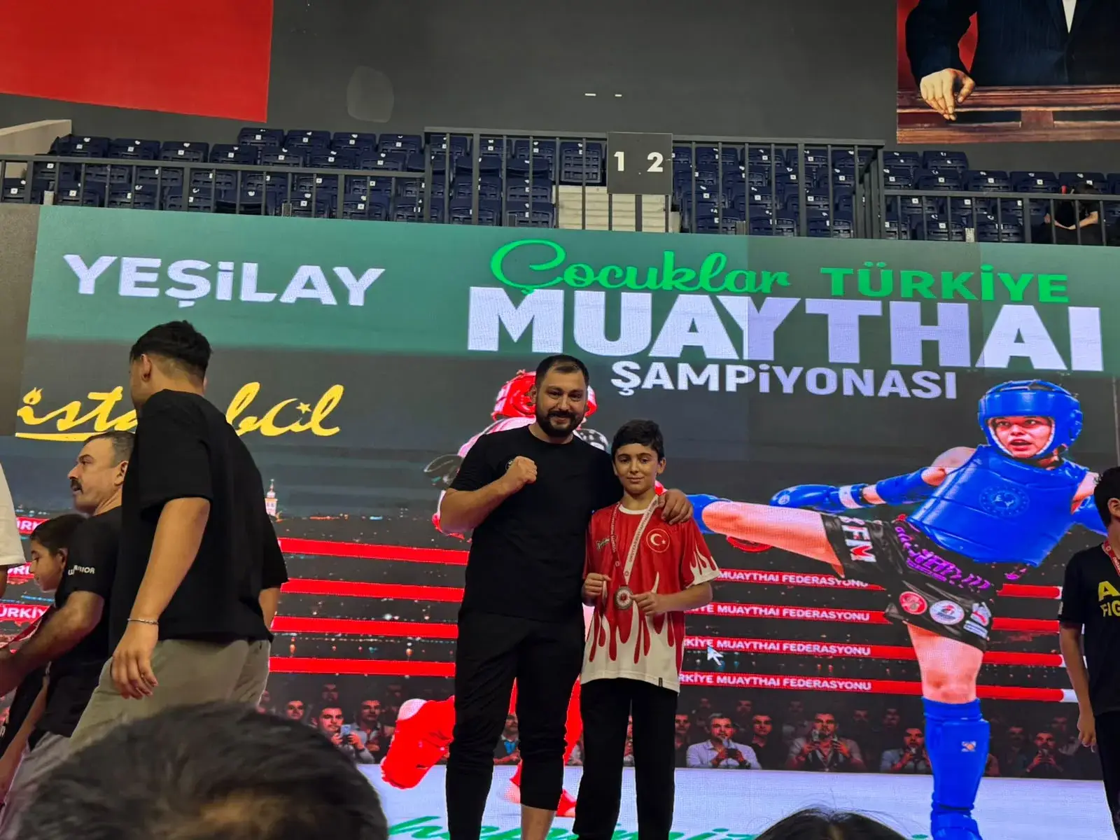 Antrenör sporcusuna madalyasını takıyor
