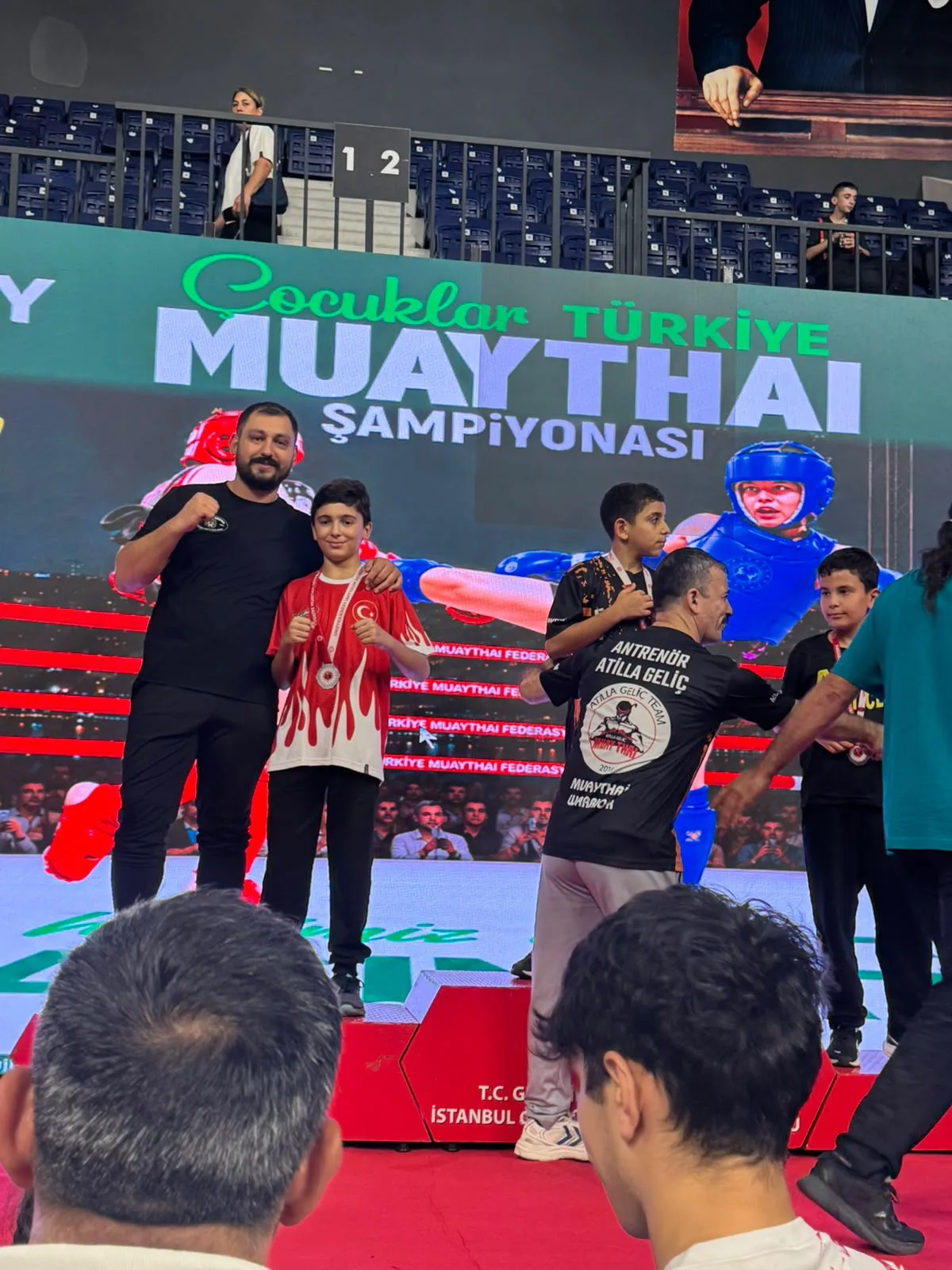 Antrenör ve madalyalı sporcu kürsü sonrası