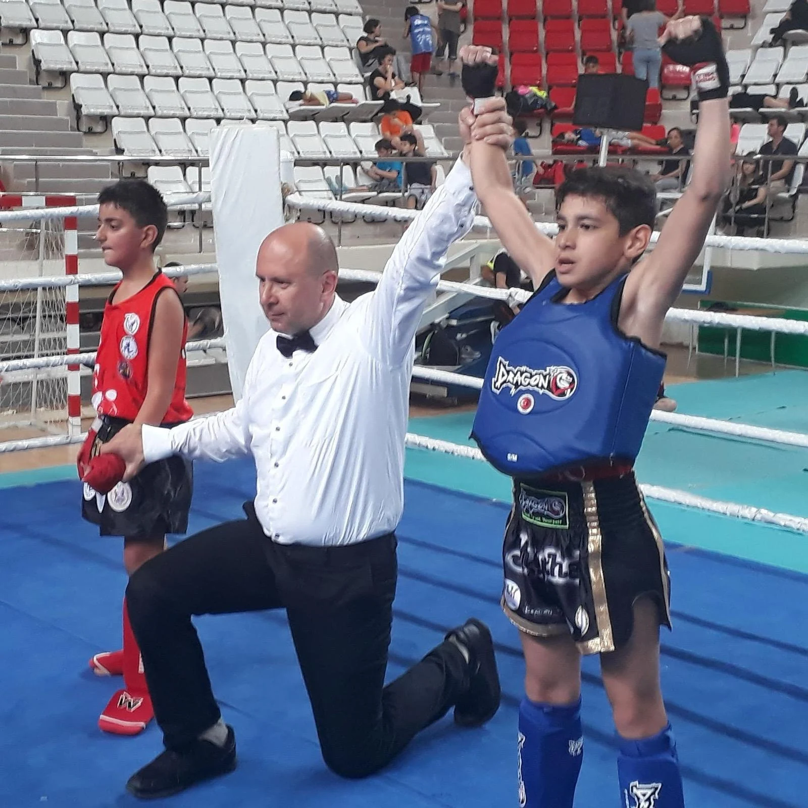 Hakem genç sporcunun elini kaldırarak galibiyeti ilan ediyor